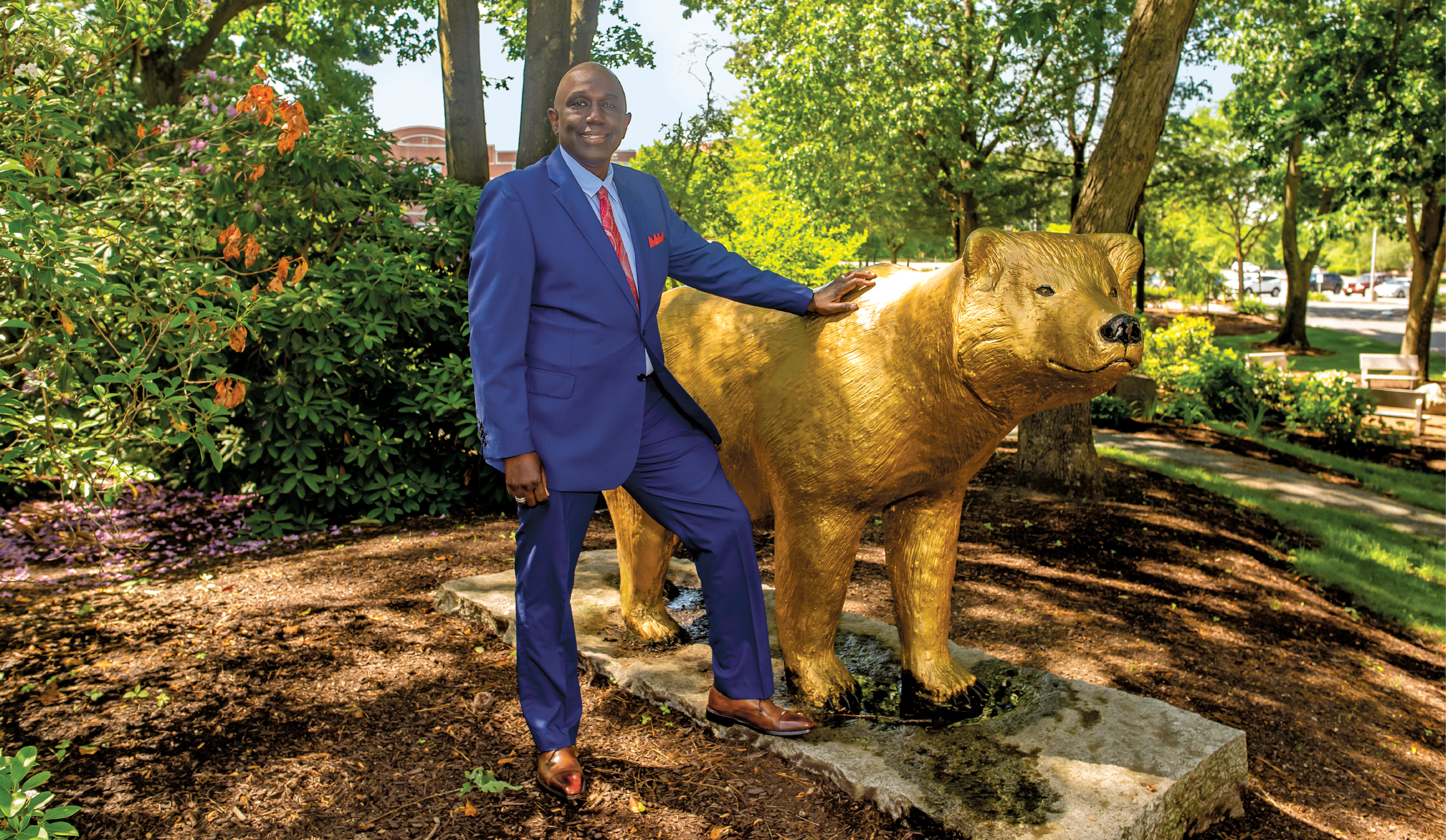 President Johnson standing with golden bear statue